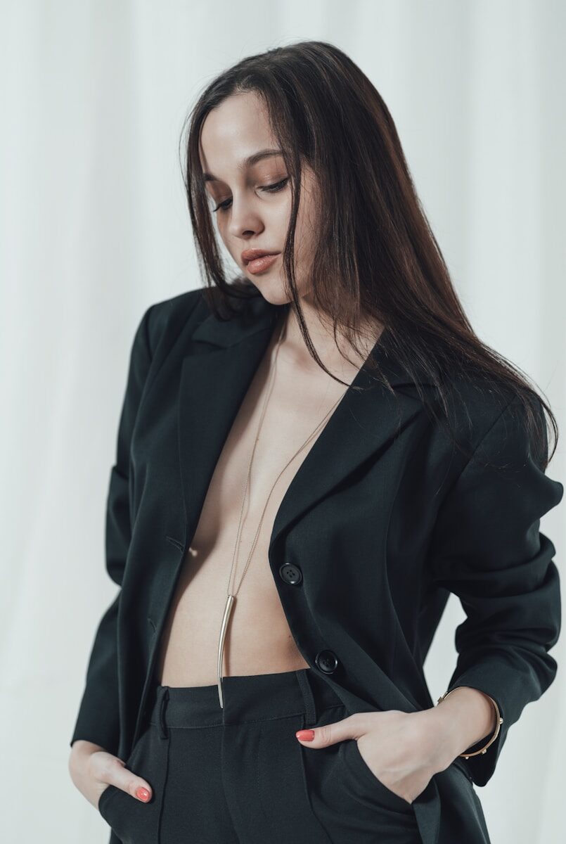 a woman in a black suit with her hands on her hips